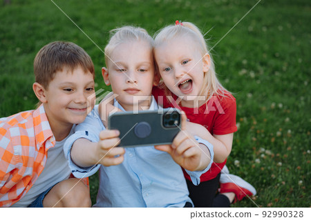 cute funny children shooting selfie with smartphone 92990328