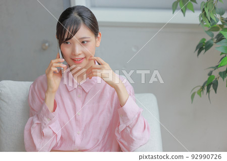 Bird's eye view _ Woman 1 who speaks with a slightly troubled face with her finger on her cheek 92990726