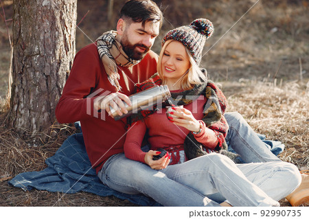 Couple by the tree. People in a spring forest. Pair with thermos. 92990735