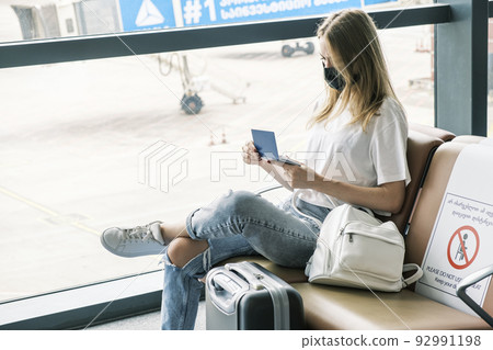 Biometric Ukrainian passport is in hands of woman waiting for flight at the airport. Citizen of Ukraine is forced to leave her home because of war with Russia. Ukrainian refugees are immigrants abroad Biometric Ukrainian passport is in hands of woman waiting for flight at the airport. Citizen of Ukraine is forced to leave her home because of war with Russia. Ukrainian refugees are immigrants abroad 92991198