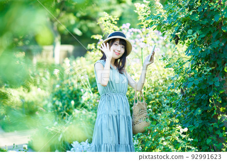 Woman taking pictures while walking Woman taking pictures while walking 92991623