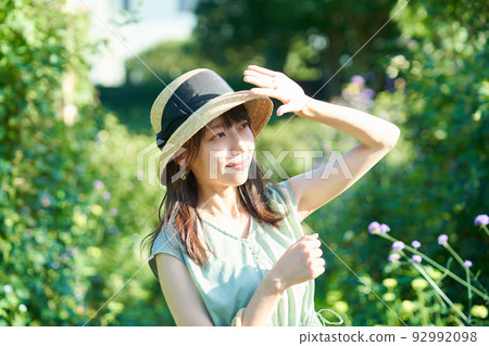 A woman blocking the strong sunlight with her hand A woman blocking the strong sunlight with her hand 92992098
