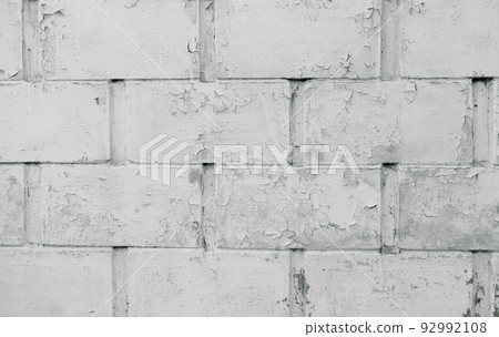 Old wall with cracked surface and unattractive gliding color, white brick background. Photo of an old white brick wall texture. The surface of the white brick wall of the house is being cleaned. Old wall with cracked surface and unattractive gliding color, white brick background. Photo of an old white brick wall texture. The surface of the white brick wall of the house is being cleaned. 92992108