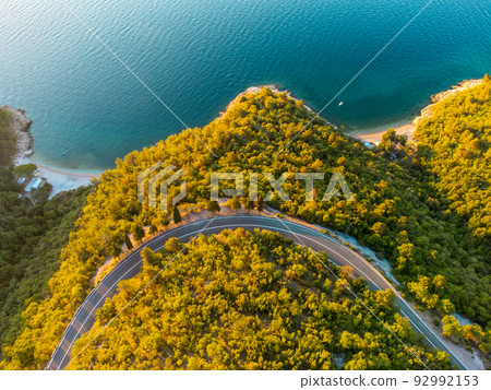 Winding coastal road at sunrise 92992153