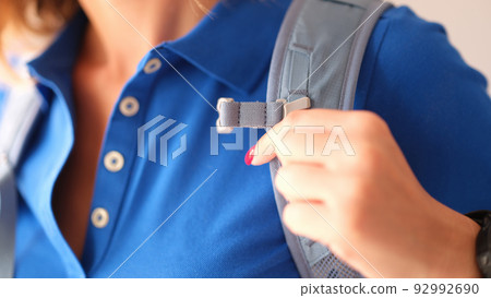 Closeup of woman in blue polo and gray harness of sports backpack Closeup of woman in blue polo and gray harness of sports backpack 92992690