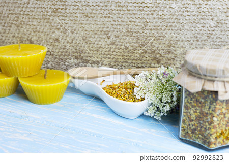 raw organic bee pollen on a wooden board surrounded by wildflowers 92992823