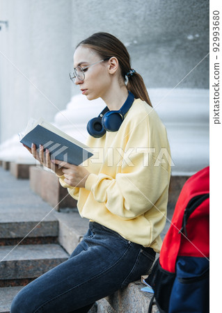 Positive daily affirmations for self love. Young woman in headphones writing in notebook 92993680
