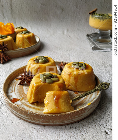 Pumpkin pannacotta with seeds on a gray background. Pumpkin pannacotta with seeds on a gray background. 92994914