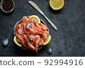 Frozen shrimps with lemon and ice on a dark background. 92994916