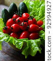 Fresh vegetables: cherry tomatoes, cucumbers and green salad leaves. 92994927