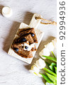 Chocolate pancakes on a white background in composition with tulips. 92994936