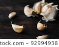 Garlic cloves on a dark wooden table. 92994938