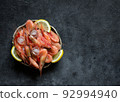 Raw shrimps with lemon and ice on a dark background. 92994940