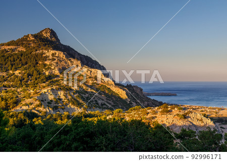 Rocky coast with Tsambika beach on the island of Rhodes, Greece. Rocky coast with Tsambika beach on the island of Rhodes, Greece. 92996171