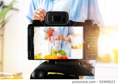Vlogger woman chef records a video of cooking recipe 92996623