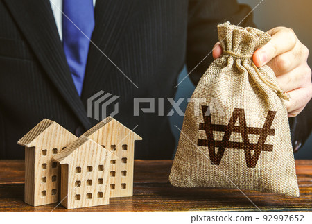 South korean won money bags and residential buildings figures. Investments in real estate and construction industry. Bank offer of mortgage loan. Rental business. Sale of housing. Municipal budget. 92997652