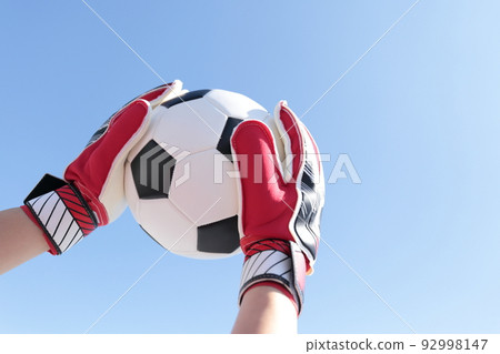 Goalkeeper man catching a soccer ball 92998147