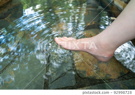 一個女人把她的腳放在溫泉里 一個女人把她的腳放在溫泉里 92998728