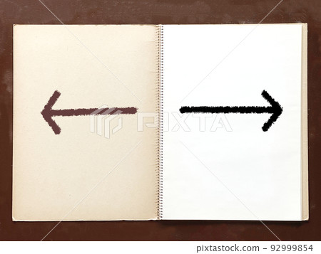 Left and right arrows on an open old sketchbook on a desk Left and right arrows on an open old sketchbook on a desk 92999854