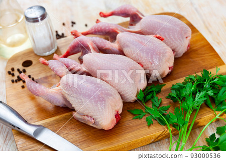 Quail carcasses lie on cutting board. Small birds are prepared for cooking Quail carcasses lie on cutting board. Small birds are prepared for cooking 93000536