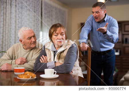 Adult son argues with his elderly parents at home 93000774