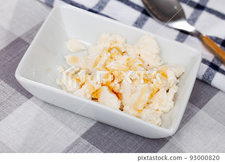 Portion of cottage cheese with sweet honey close up Portion of cottage cheese with sweet honey close up 93000820