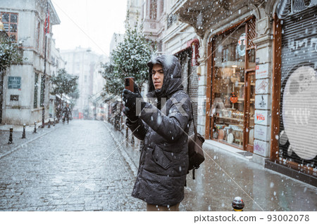 man taking picture with his smartphone while travelling 93002078