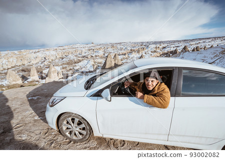 young man when getting on top of the hill by his car 93002082