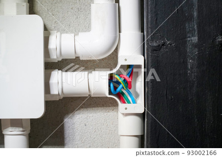 Electrician open cap of PVC inspection tee fitting on wall 93002166