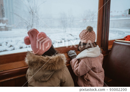 little girl enjoy riding a tram during winter snow little girl enjoy riding a tram during winter snow 93002200