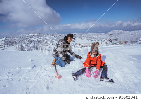 father and daughter playing with snow in the mountain peak 93002341
