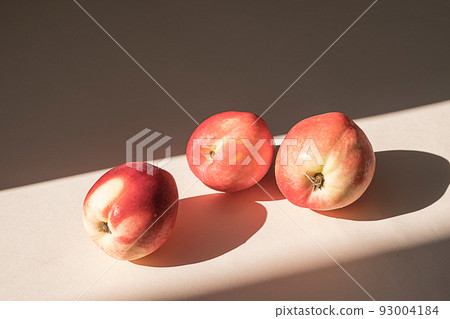 Peaches in sunlight. Minimalism, trendy still life with shadow. 93004184