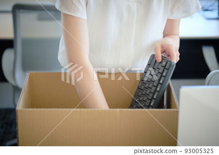 A woman packing her belongings in a cardboard box photo material 93005325
