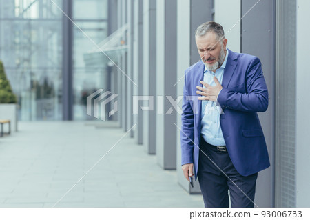 Senior gray-haired banker boss sick outside office building, banker has severe chest pain, heart aches Senior gray-haired banker boss sick outside office building, banker has severe chest pain, heart aches 93006733