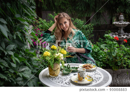 Young stylish woman holding a cup in the garden at Home 93008883
