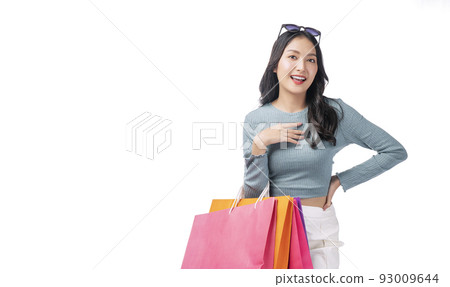 Excited asian woman with sunglasses holding shopping bags standing on white background. Excited asian woman with sunglasses holding shopping bags standing on white background. 93009644