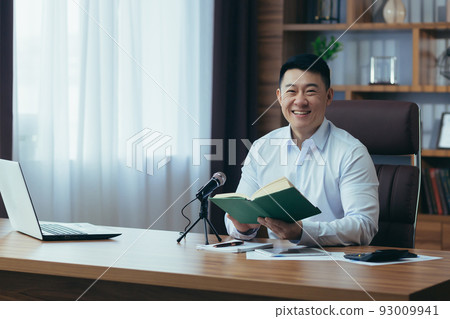 Asian freelancer records audio podcasts, businessman works in office, uses professional microphone and laptop Asian freelancer records audio podcasts, businessman works in office, uses professional microphone and laptop 93009941