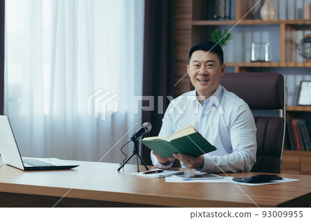 Asian freelancer records audio podcasts, businessman works in office, uses professional microphone and laptop 93009955