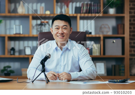 Asian freelancer records audio podcasts, businessman works in office, uses professional microphone and laptop 93010203