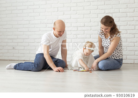 Baby child with hearing aids and cochlear implants plays with parents on floor. Deaf and rehabilitation concept 93010619