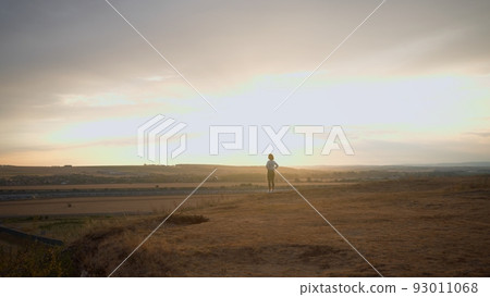 Sport woman running on sunny hill during the evening Sport woman running on sunny hill during the evening 93011068