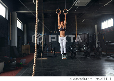 Female Athlete Performing Pull-ups on Gymnastic Rings Female Athlete Performing Pull-ups on Gymnastic Rings 93011191