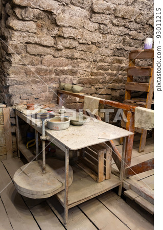 Potter's workshop. A working table with clay and a potter's wheel. Potter's workshop. A working table with clay and a potter's wheel. 93011215