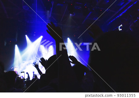 Silhouettes of a concert crowd in front of an illuminated stage in a nightclub. Silhouettes of a concert crowd in front of an illuminated stage in a nightclub. 93011355