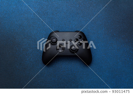 Game controller on a blue background. Black joystick for computer games top view. Game controller on a blue background. Black joystick for computer games top view. 93011475