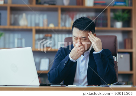 Businessman working in the office, sick Asian has a cold and flu, runny nose from allergies Businessman working in the office, sick Asian has a cold and flu, runny nose from allergies 93011505