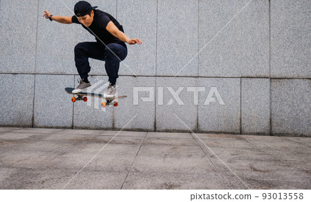 Asian woman skateboarder skateboarding in modern city Asian woman skateboarder skateboarding in modern city 93013558