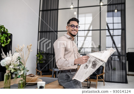 Man with newspaper smiling at camera Man with newspaper smiling at camera 93014124