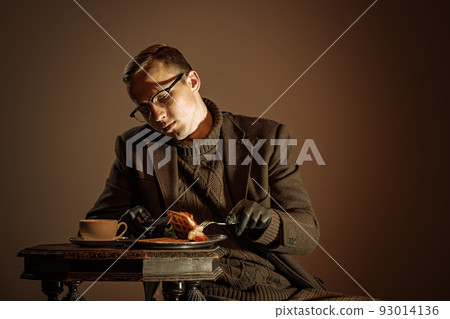 Retro style portrait of young man, writer and traveler wearing vintage style clothes isolated over dark brown background. Business, art, fashion concept Retro style portrait of young man, writer and traveler wearing vintage style clothes isolated over dark brown background. Business, art, fashion concept 93014136