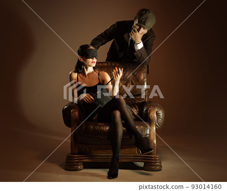 Intrigue. Vintage style portrait of man and woman in 1920s style fashion outfits isolated over dark brown background. Relationship, business, love, art, fashion Intrigue. Vintage style portrait of man and woman in 1920s style fashion outfits isolated over dark brown background. Relationship, business, love, art, fashion 93014160